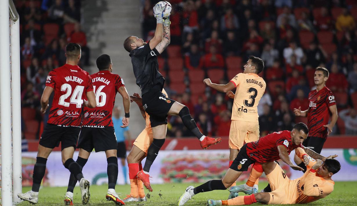 Kiper RCD Mallorca, Predrag Rajkovic menghalau bola saat laga lanjutan Liga Spanyol 2022/2023 melawan Atletico Madrid di Mallorca Stadium, 9 November 2022. Rajkovic direkrut Mallorca pada bursa transfer musim panas 2022/2023 dari Stade Reims. Ia kini menjadi kiper andalan Los Bermellones. (AFP/Jaime Reina)
