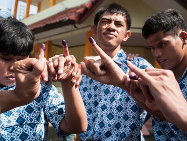 Penyandang disabilitas menunjukan jarinya usai pencoblosan pada Pilkada Putaran kedua di TPS 07 Kelurahan Cawang, Jakarta, Rabu (19/4). Penyandang disabilitas boleh membawa pendamping selama pencoblosan. (Liputan6.com/Gempur M. Surya)