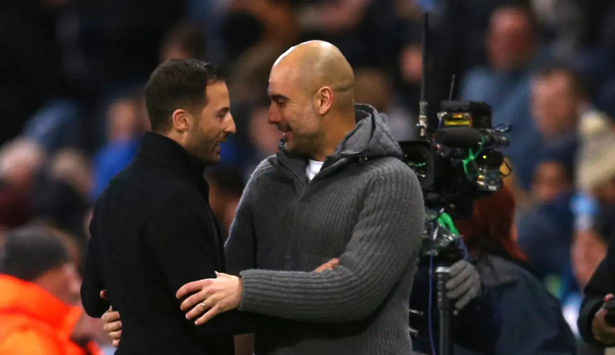 Pelatih Manchester City Pep Guardiola (kanan) memeluk pelatih Schalke Domenico Tedesco usai laga leg kedua babak 16 besar Liga Champions di Etihad Stadium, Manchester, Selasa (12/3). City membantai Schalke 7-0. (AP Photo/Dave Thompson)