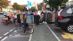 PKL menutup sebagian badan trotoar di kawasan Jatinegara, Jakarta, Senin (24/9). Kondisi trotoar yang telah diperlebar Pemprov DKI Jakarta kini dipenuhi PKL dan parkir liar sehingga mengganggu kenyamanan pejalan kaki. (Liputan6.com/Immanuel Antonius)