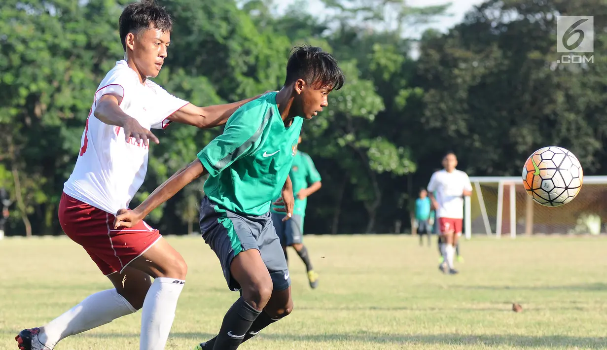 Pemain Timnas Indonesia U-16 (kaus hijau) berebut bola dengan pemain Asian School U-18 di Lapangan Atang Sutresna, Jakarta, Jumat (25/8). Uji tanding ini persiapan jelang kualifikasi Piala Asia U-16, September mendatang. (Liputan6.com/Helmi Fithriansyah)