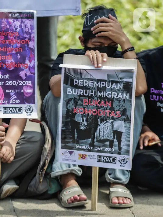 Pengunjukrasa dari Serikat Buruh Migran Indonesia membawa poster dalam aksi di depan Kementerian Ketenagakerjaan, Jakarta, Rabu (18/12/2019). Aksi  memperingati Hari Buruh Migran Internasional itu mendesak Negara bertanggung jawab atas perlindungan hak buruh migran. (Liputan6.com/Faizal Fanani)