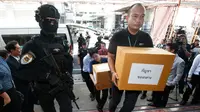 Petugas membawa 100 kilogram ganja yang disita sebelum konferensi pers di Bangkok, Selasa (25/9). Kepolisian Thailand menyerahkan ganja sitaan itu untuk penelitian medis menyusul rencana pemerintah memproduksi obat-obatan berbasis ganja (AP/Sakchai Lalit)
