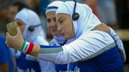 Gaya pemain bola putri dari Iran saat berfoto selfie sebelum berlaga melawan Jerman pada ajang  Discover Football tournamen di Berlin, Jerman, (31/8/2016). (REUTERS/Stefanie Loos)