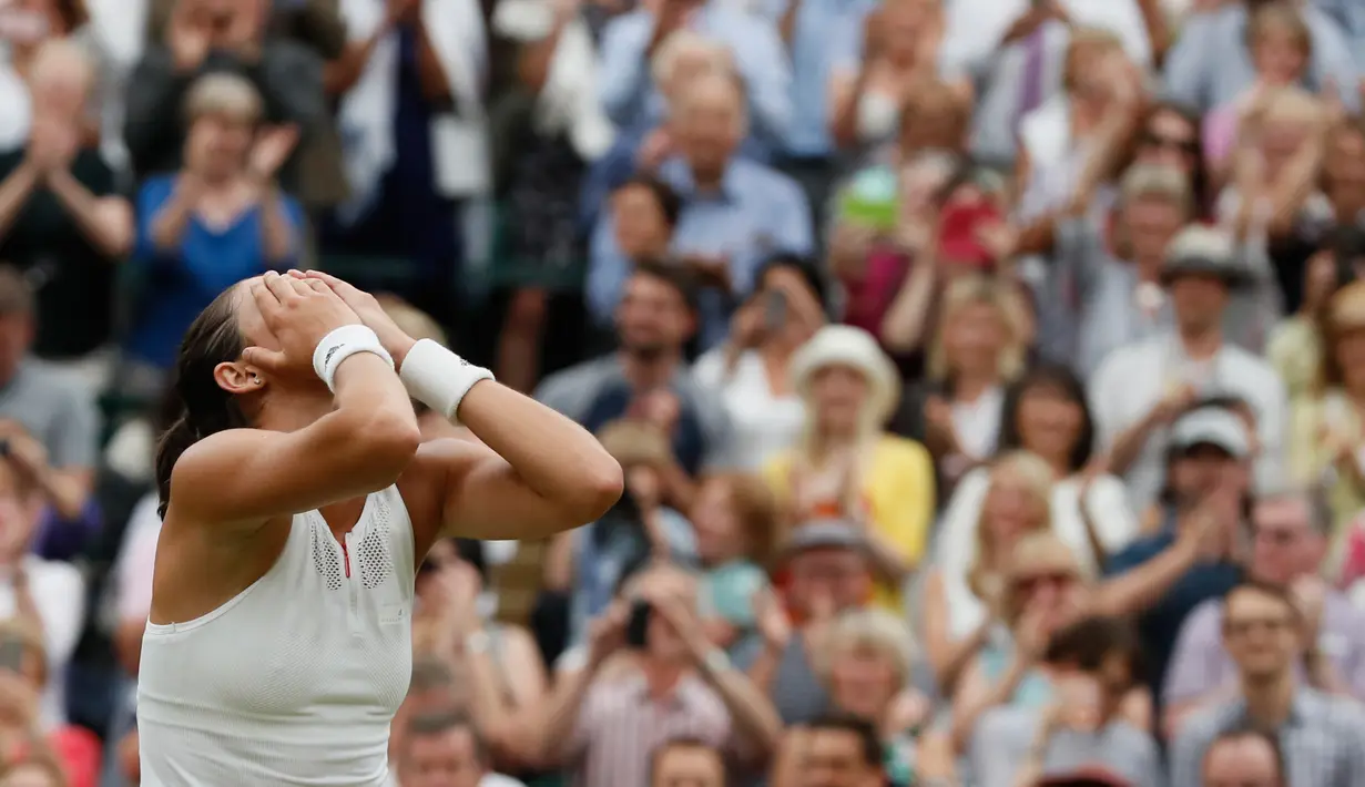 Petenis Spanyol, Garbine Muguruza bereaksi usai mencetak poin atas petenis AS Venus Williams pada final turnamen grand slam Wimbledon di London, Sabtu (15/7). Kemenangan itu mengantar Muguruza pada gelar perdana di Wimbledon (AP Photo/Kirsty Wigglesworth)