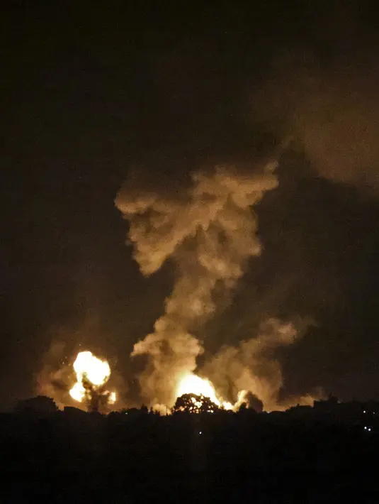 Asap dan bola api membubung menyusul serangan udara di Khan Yunis, Jalur Gaza, Minggu (2/1/2022). Israel melancarkan serangan udara terhadap Gaza. (SAID KHATIB/AFP)