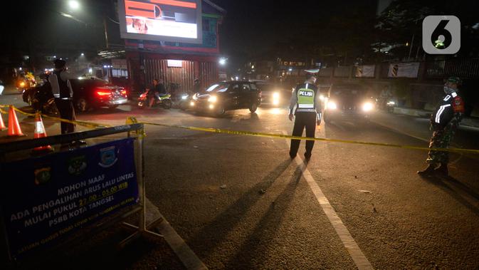 Polisi dibantu Satpol PP dan Dishub mengatur lalu lintas pengalihan arus di depan RS Sari Asih, Tangerang Selatan, Banten, Sabtu (9/5/2020). Pengalihan arus dalam rangka pelaksanaan PSBB untuk memutus penularan Covid-19 di wilayah Tangsel mulai jam 22.00 hingga 05.00. (merdeka.com/Dwi Narwoko)