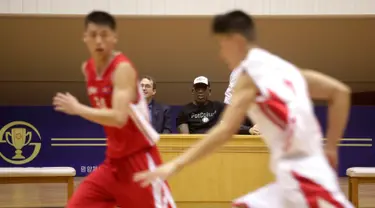 Mantan bintang basket NBA Dennis Rodman (tengah) duduk bersama Joseph Terwilliger, Academic at Columbia University, menyaksikan pertandingan tim basket Korea Utara di Pyongyang, Korea Utara (15/6). (AP Photo/Kim Kwang Hyon)