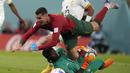 Penyerang Portugal Cristiano Ronaldo jatuh di atas kiper Ghana Lawrence Ati-Zigi  pada duel grup H Piala Dunia 2022 di stadion 974, Kamis (24/11/2022). Cristiano Ronaldo mencetak satu gol dalam kemenangan 3-2 Portugal atas Ghana. (AP Photo/Darko Bandic)