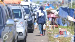 Warga menjual bensin kepada para pemudik yang mengantri di pintu tol Brebes Timur, Minggu (3/7). Warga menjual bensin dagangannya seharga perderigennya Rp 80 ribu. (Liputan6.com/Angga Yuniar)