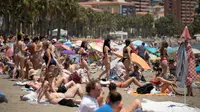 Sejumlah turis memenuhi pinggir pantai di Malaga, Spanyol, untuk berjemur. (dok. JORGE GUERRERO / AFP)