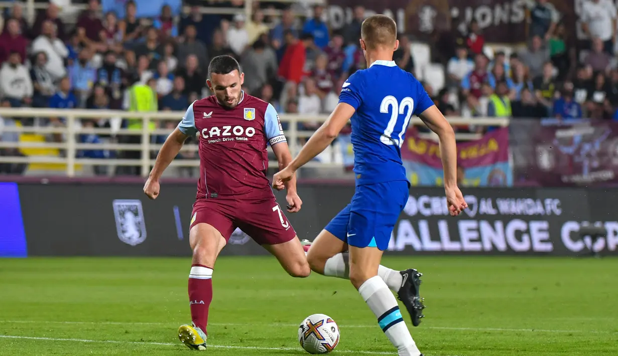 Gelandang Aston Villa,  John McGinn (Kiri) menendang bola untuk mencetak gol ke gawang Chelsea selama pertandingan pertandingan uji coba di Stadion al-Nahyan di Abu Dhabi (11/12/2022). Aston Villa menang tipis atas Chelsea dengan skor 1-0. (AFP/Ryan Lim)
