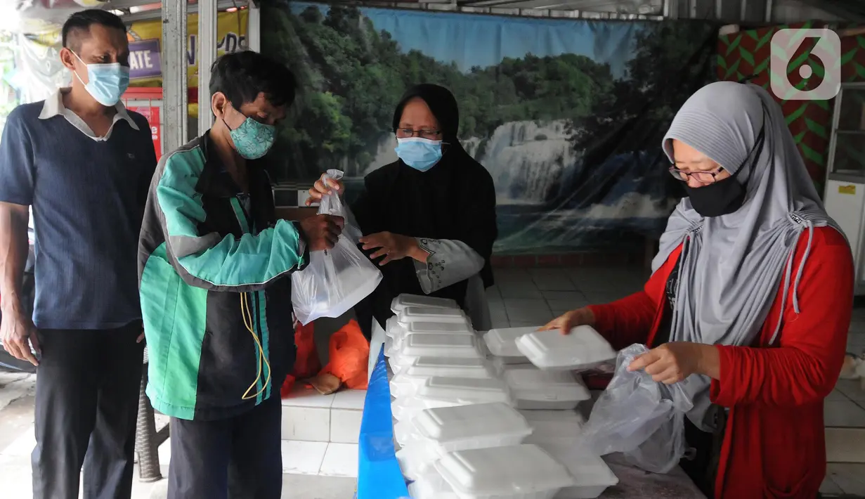 Relawan Yayasan Nasi Jumat (SiJum) Indonesia memberikan  makan siang di Warung Makan Gratis Beji, Depok, Jawa Barat, Rabu (9/3/2022). Makan siang gratis bagi masyarakat umum setiap harinya ini sudah berjalan sejak September 2021. (merdeka.com/Arie Basuki)