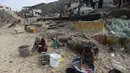 Warga Palestina menggunakan air laut untuk mandi dan membersihkan peralatan serta pakaian mereka akibat kekurangan air yang terus berlanjut di Jalur Gaza, di pantai Deir al-Balah, Jalur Gaza Tengah, Minggu, 29 Oktober 2023. (AP Photo/Mohammed Dahman)