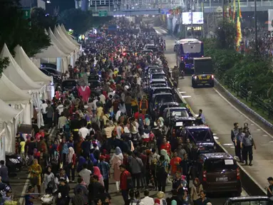 Warga memadati malam pergantian tahun di Jalan MH Thamrin, Jakarta, Minggu (31/12). Pemprov DKI Jakarta memberlakukan car free night di Jalan Sudirman hingga Thamrin. (Liputan6.com/Angga Yuniar)