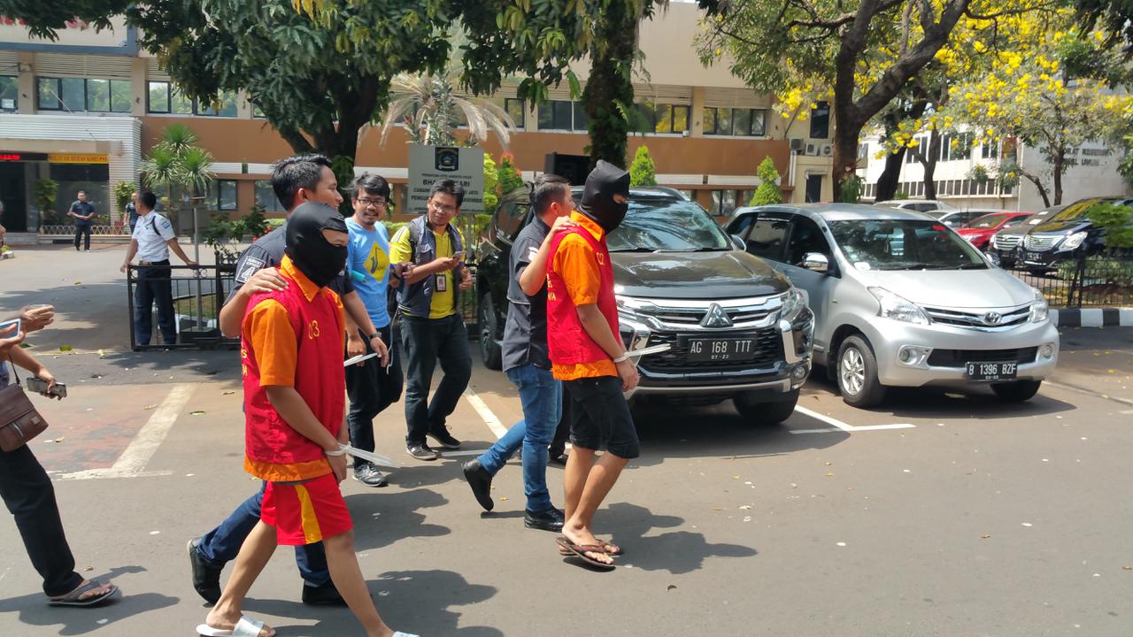 Pelaku penyebar konten pornografi gay anak digiring polisi di Mapolda Metro jaya. (Nanda Perdana/Liputan6.com)