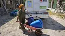 Warga membawa jeriken berisi air bersih yang didistribusikan oleh Palang Merah Indonesia (PMI) Kabupaten Bangkalan di Dusun Batangan Tengah, Desa Batangan, Kecamatan Tanah Merah, Kabupaten Bangkalan, Jawa Timur, Selasa (21/7/2026). (AFP/ Juni Kriswanto