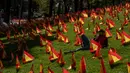 Seorang pria duduk di antara bendera Spanyol untuk mengenang korban COVID-19 di Madrid, Minggu (27/9/2020). Asosiasi keluarga korban virus corona memasang 53.000 bendera kecil Spanyol di sebuah taman Madrid untuk menghormati mereka yang meninggal akibat pandemi. (AP Photo/Manu Fernandez)