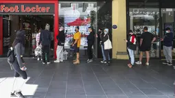 Pelanggan mengantre di luar pengecer pakaian olahraga di Melbourne, Australia, Rabu (28/10/2020). Melbourne, kota terbesar kedua Australia, akhirnya dibuka kembali setelah pemberlakuan lockdown yang ketat selama lebih dari tiga bulan akibat Covid-19.  (AP Photo/Asanka Brendon Ratnayake)