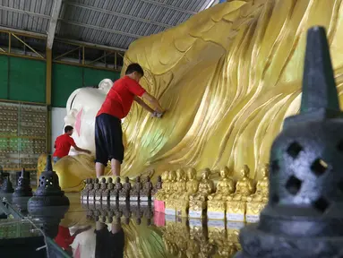 Pekerja membersihkan patung Buddha Tidur di Vihara Buddha Dharma dan 8 Pho Sat, Desa Tonjong, Tajurhalang, Bogor, Selasa (25/5/2021). Vihara itu mulai dihias dan dibersihkan untuk memberi kenyamanan bagi umat Budha yang akan beribadah saat peringatan Hari Raya Waisak. (Liputan6.com/Herman Zakharia)