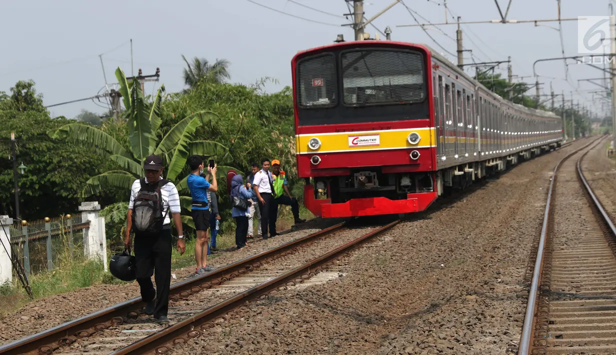 Sejumlah penumpang KRL Commuter Line terpaksa berjalan kaki menuju Stasiun Bojonggede, Bogor, Jawa Barat, Minggu (4/8/2019). Padamnya listrik di wilayah Jabodetabek mengakibatkan perjalanan KRL Commuter Line terhenti. (Liputan6.com/Helmi Fithriansyah)