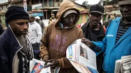 Warga membaca koran di daerah kumuh Kawangare di Nairobi (10/8). Warga Kenya tengah menunggu hasil pemilihan presidennya, antara Uhuru Kenyatta dan pesaingnya, Raila Odinga. (AFP Photo/Marco Longari) 