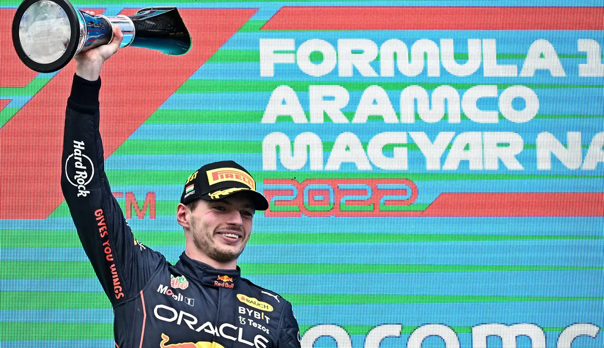 Pebalap Oracle Red Bull Racing, Max Verstappen mengangkat trofi usai memenangkan balapan Formula 1 GP Hungaria yang berlangsung di Sirkuit Hongaronging, Budapest, pada Minggu (31/7/2022). (AFP/Attila Kisbenedek)