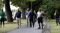 Warga menunggu dekat lokasi penembakan di Masjid Al Noor, Christchurch, Selandia Baru, Jumat (15/3). Polisi masih menyisir lokasi kejadian dan mengosokan seluruh ruas jalan Deans Avenue. (AP Photo/Mark Baker)