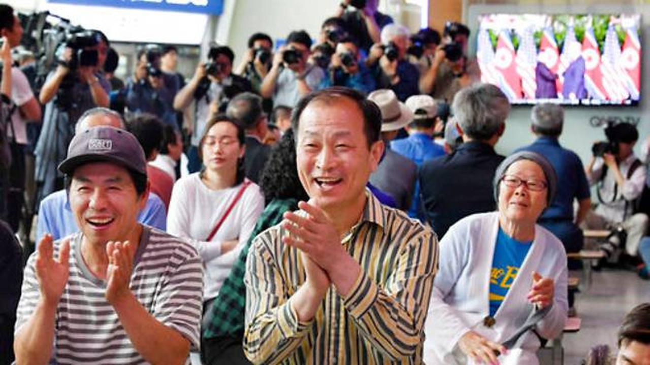 Warga Korea menyaksikan pertemuan bersejarah Donald Trump dan Kim Jong-un di Singapura melalui televisi di Seoul Railway Station. (AP)