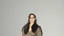 Ameera Khan tampil mengenakan trench coat khaki dengan kerah bulu cokelat tebal. Dipadu sabuk kulit hitam yang dililit vertikal, kacamata rectangle bertona cokelat, tas mini merah dan boots kulit cokelat bertumit tinggi. [dok. Burberry]