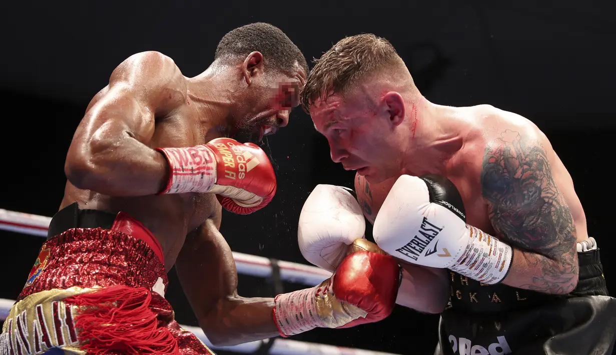 Petinju Amerika Serikat Jamel Herring (kiri) dan petinju Inggris Carl Frampton bertukar pukulan pada pertarungan gelar dunia kelas bulu super WBO di Dubai, UEA, Minggu (4/4/2021). (AP Photo/Kamran Jebreili)