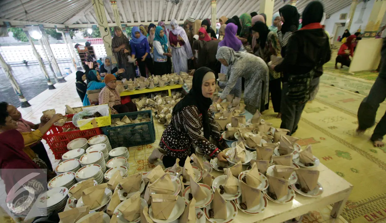 Sejumlah warga mengantri untuk mendapatkan nasi bungkus jelang buka puasa di Masjid Kauman,Yogyakarta, Senin (6/6).Takjil buka puasa di Masjid Kauman menjadi tradisi selama Ramadan setiap tahun. (Liputan6.com/Boy Harjanto)