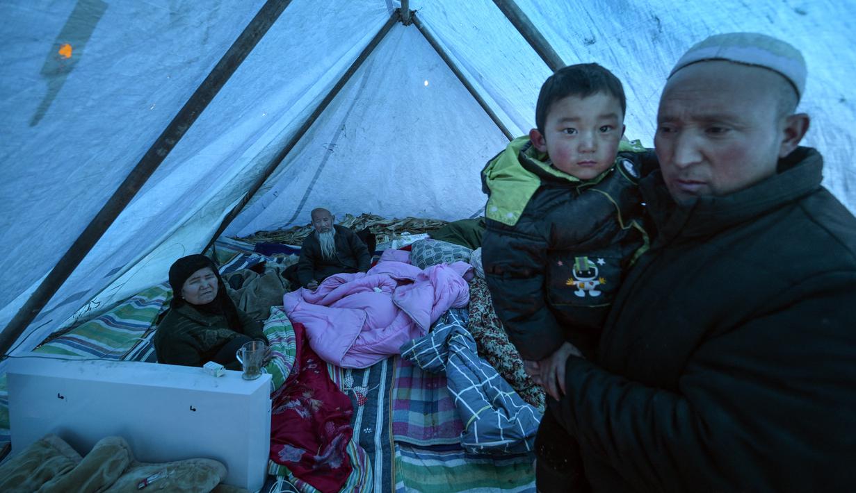 Wartawan AFP melihat keluarga-keluarga berlindung di tenda-tenda darurat yang dibangun dari tiang-tiang kayu dan terpal di luar masjid Majiahe di dekat pusat gempa. (Pedro Pardo / AFP)