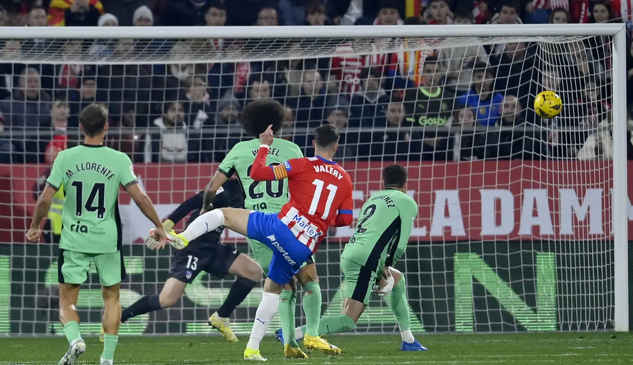 Bek Girona, Valery Fernandez (tengah) melepaskan tendangan yang menghasilkan gol pertama timnya ke gawang Atletico Madrid pada laga pekan ke-19 Liga Spanyol 2023/2024 di Montilivi Stadium, Girona, Kamis (4/1/2024) dini hari WIB. (AFP/Pau Barrena)