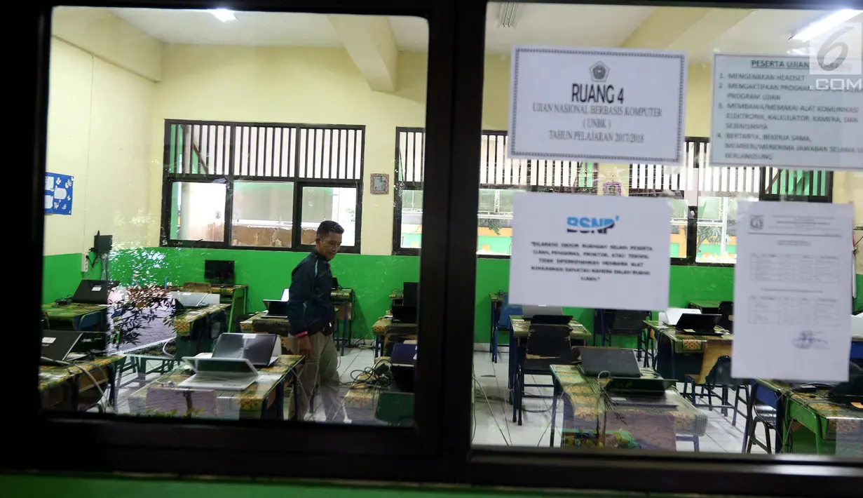 Petugas mengecek kesiapan laptop dan ruang untuk Ujian Nasional Berbasis Komputer di SMP N 34 Pademangan, Jakarta Utara, Minggu (22/4). UNBK SMP 2018 akan berlangsung mulai besok Senin (23/4). (Liputan6.com/Johan Tallo)
