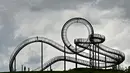 Orang-orang berjalan di sebuah instalasi tangga melingkar "Tiger and Turtle" di Duisburg, Jerman, 30 April 2018. Instalasi seni ini adalah patung jalan setapak menyerupai roller coaster yang berada di atas puncak bukit. (AP/Martin Meissner)