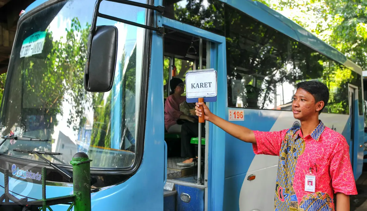 Petugas feeder bus Transjakarta sedang menunggu calon penumpang di seberang Stasiun Tebet , Jakarta, Kamis (7/4). Pengoperasian ini bagian dari antisipasi penumpukan penumpang saat perlintasan KRL Tebet ditutup. (Liputan6.com/Yoppy Renato)