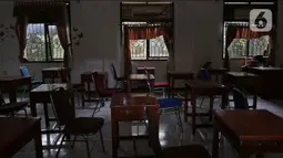 Suasana ruang kelas kosong saat PTMT dihentikan di SMPN 2 Depok, Pancoran Mas, Depok, Jawa Barat, Jumat (19/11/2021). Pelaksanaan PTMT sementara hingga 29 November 2021 akibat terjadinya penambahan kasus COVID-19 yang berasal dari klaster PTMT. (Liputan6.com/Herman Zakharia)