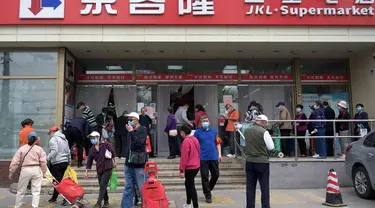 Orang-orang mengantre di luar supermarket untuk membeli persediaan makanan di Beijing pada 25 April 2022. Kekhawatiran penguncian Covid memicu pembelian panik dan antrean panjang untuk pengujian massal di Beijing pada 25 April ketika otoritas China bergegas untuk membasmi wabah di ibu kota. (AFP/Noel Celis)