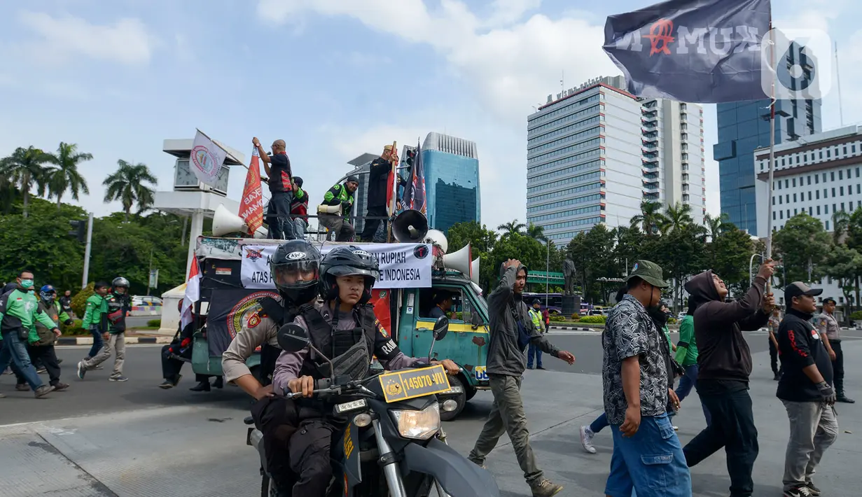 Pengemudi ojek online (ojol) berjalan menuju Kementerian Perhubungan (Kemenhub) untuk menggelar unjuk rasa di Jakarta, Rabu (15/1/2020). Para driver ojol ini menyuarakan beberapa tuntutannya terkait kejelasan payung hukum atau legalitas dari ojek online. (merdeka.com/Imam Buhori)