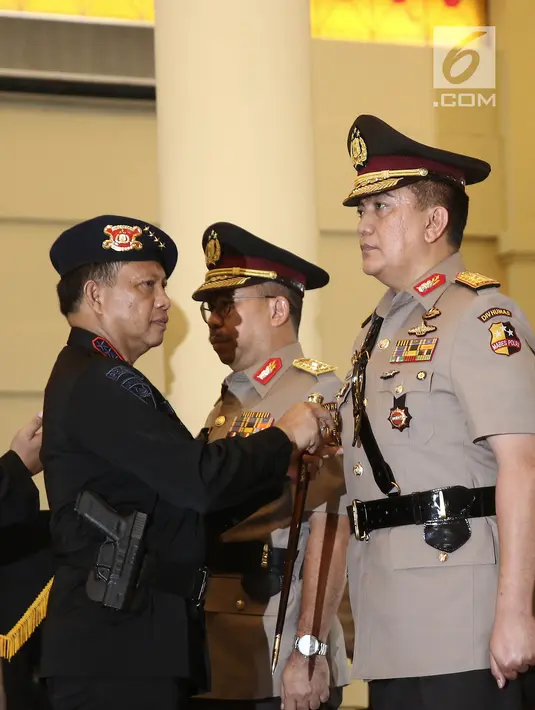 Kapolri Jenderal Tito Karnavian menyematkan lencana jabatan pada Brigjen Muhammad Iqbal selama upacara sertijab di Mako Brimob, Kelapa Dua, Depok, Rabu (14/ 11). Iqbal menjabat Kadiv Humas menggantikan Irjen Setyo Wasisto. (Liputan6.com/Herman Zakharia)