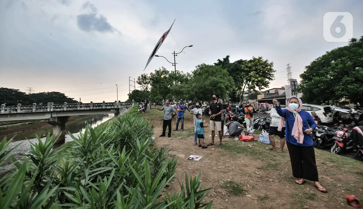 Warga bermain layang-layang di pinggir Kanal Banjir Timur (KBT), Duren Sawit, Jakarta, Senin (19/4/2021). KBT menjadi lokasi favorit warga untuk mengisi waktu menunggu buka puasa atau ngabuburit, salah satunya dengan bermain layang-layang bersama keluarga. (merdeka.com/Iqbal S Nugroho)