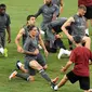 Para pemain Arsenal melakukan pemanasan saat mengikuti sesi latihan tim di Singapura (27/7). Arsenal akan bertanding melawan PSG pada International Champions Cup 28 Juli. (AFP Photo/Roslan Rahman)