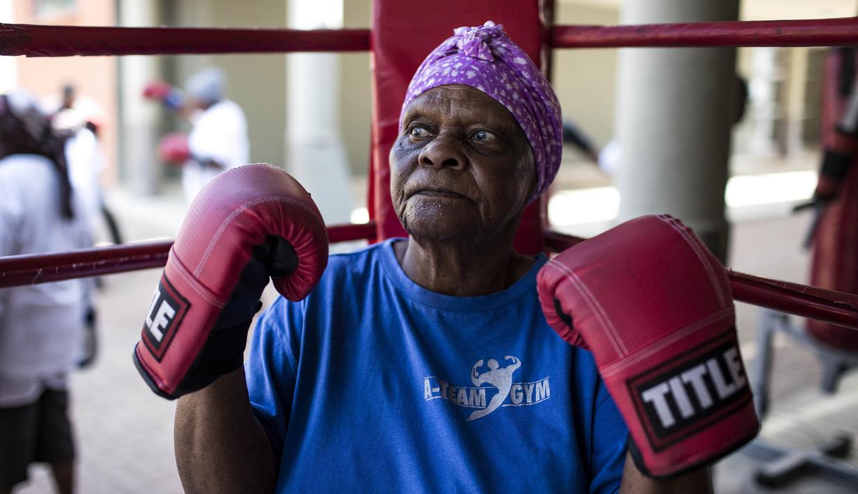 Seorang nenek berlatih tinju pada Boxing Gogos di Cosmo City, Johannesburg, Selasa (19/9/2017). Berkat latihan rutin yang dipimpin Claude Maphosa ini para lansia berhasil sembuh dari penyakit dan hidup lebih sehat. (AFP/Gulshan Khan) 