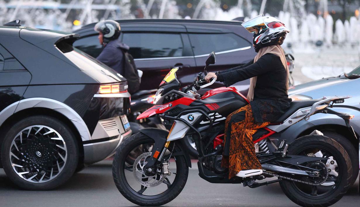 Pengendara motor perempuan mengenakan kebaya saat melintas di sekitar kawasan Bundaran Hotel Indonesia, Jakarta, Selasa (21/4/2026). Selasa sore, 21 April 2026, selepas waktu kerja, beberapa perempuan tampil penuh percaya diri mengenakan kebaya berpadu aksesori modis lainnya. (Kapanlagi.com/Budy Santoso)
