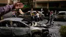 Warga dan pasukan keamanan Israel memeriksa lokasi yang terkena serangan rudal Iran di Petah Tikva, Israel, Selasa 31 Maret 2026. Serangan rudal balistik Iran kembali menghantam wilayah Petah Tikva, Israel. (AP Photo/Ohad Zwigenberg)