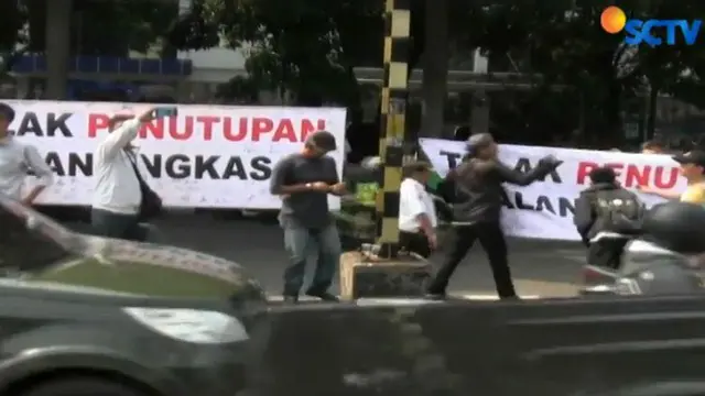 Warga berusaha mengajak pengguna jalan untuk mendukung aksi mereka dengan membentangkan kain putih sepanjang 10 meter.