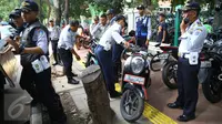 Petugas Dishub menertibkan sepeda motor yang parkir di sepanjang trotoar kawasan Kebon Sirih, Jakarta, Rabu (18/1). Puluhan motor diamankan serta digembosi dalam penertiban tersebut karena menutupi jalur pedestrian. (Liputan6.com/Immaniel Antonius)