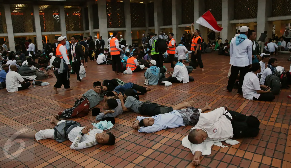 Ribuan umat muslim dari berbagai daerah sedang beristirahat usai melakukan perjalanan dan menjalankan salat Shubuh di Masjid Istiqlal, Jakarta. (04/10). Lebih dari 70 bus berukuran besar berjejer di kompleks Masjid Istiqlal. (Liputan6.com/Johan Tallo)
