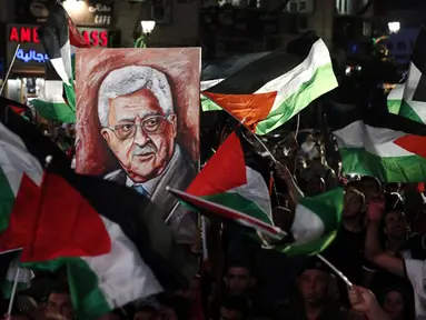 Warga Palestina membawa bendera nasional dan foto Presiden Mahmud Abbas saat menunggu live-screening pidato Presiden mereka sebelum pengibaran bendera Palestina di markas besar PPB di New York, Rabu (30/9/2015). (AFP PHOTO/ABBAS Momani)